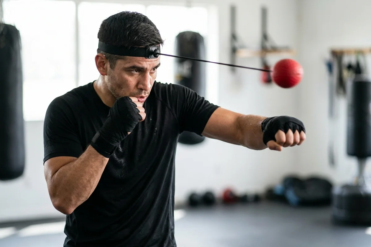 Boxeur s'entraînant avec une balle de réflexe fixée à un bandeau pour améliorer sa coordination et sa vitesse