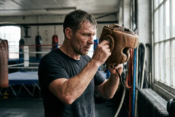 Boxeador ajustándose un casco de protección profesional para una sesión de sparring