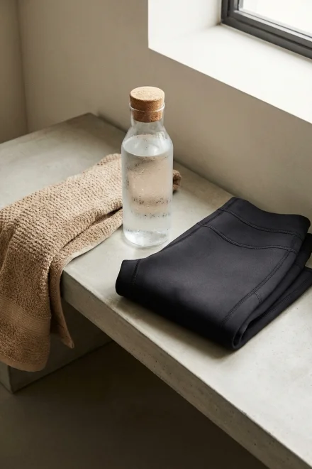 Bouteille d'eau et serviette à côté d'une combinaison de sudation