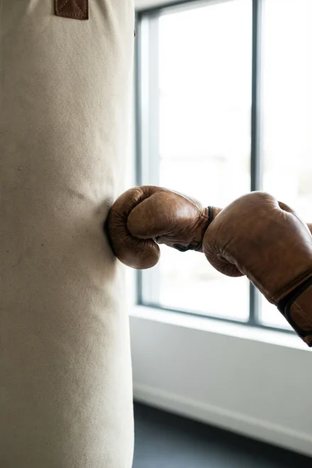 Guantes de boxeo golpeando un saco pesado de entrenamiento